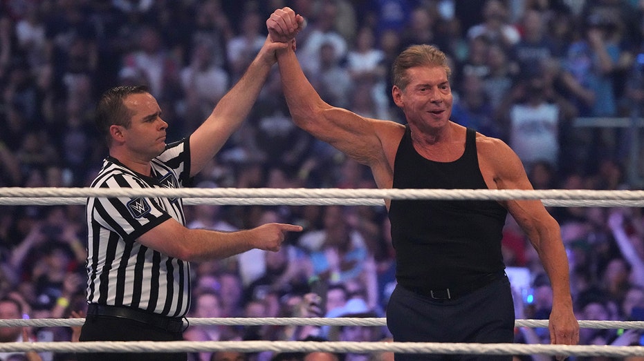Vince McMahon has his arm raised