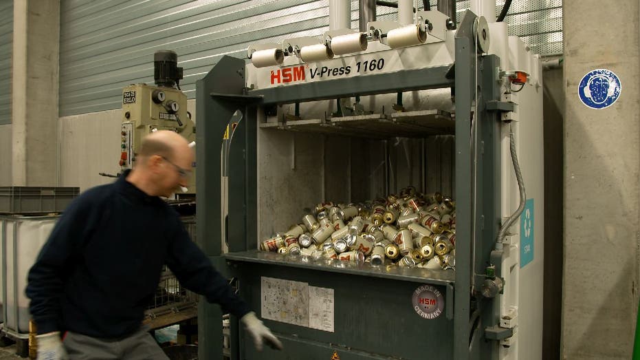 Miller High Life beer cans get crushed in machine