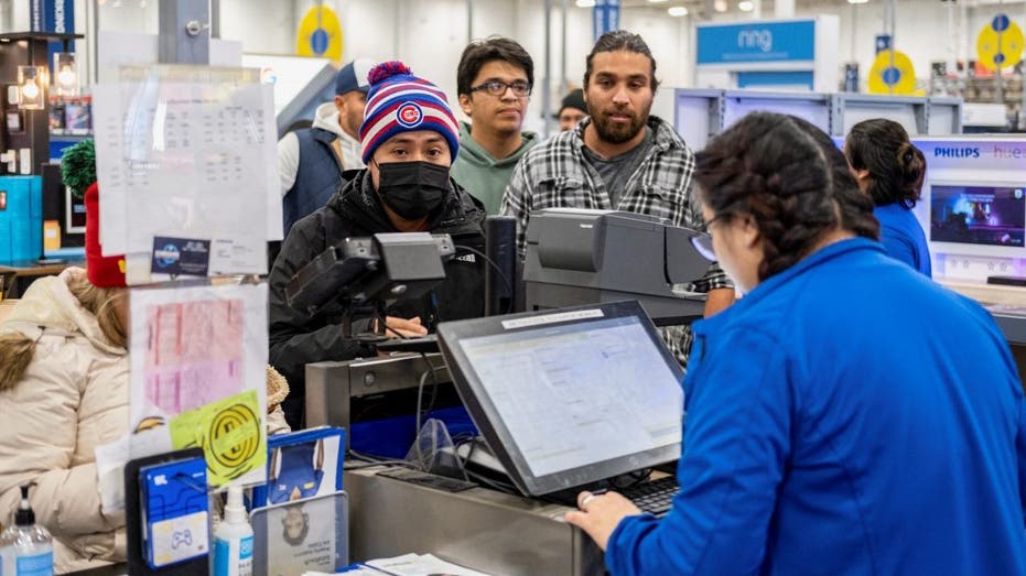 Employee checks out customers at a best buy