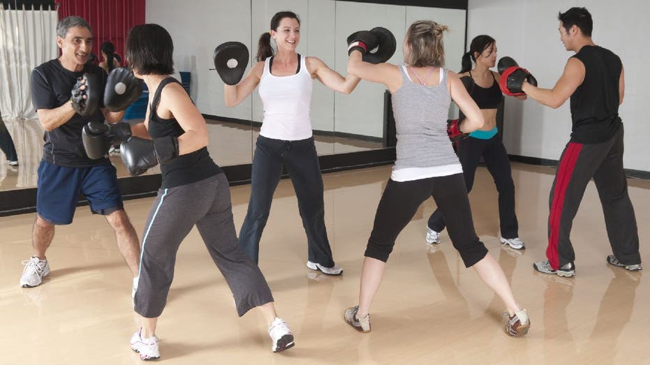 Boxing class with students hitting punching pads