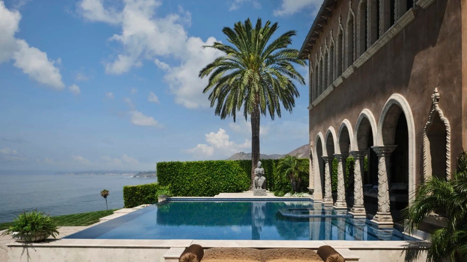 A view of the pool with a palm tree at Cher's mansion