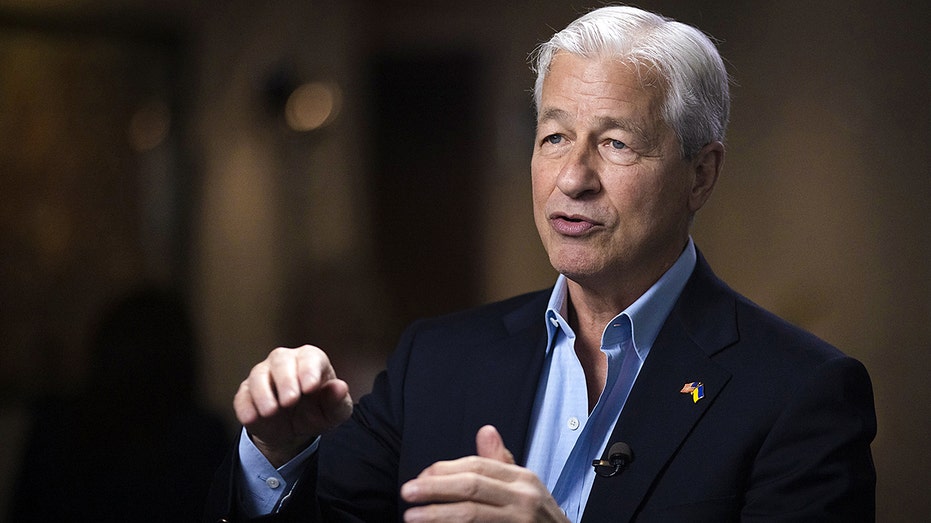 Jamie Dimon gestures with hands during an interview, with no tie and collar open