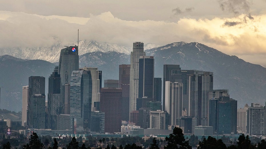 Downtown Los Angeles skyline with snow-capped mountains in the background