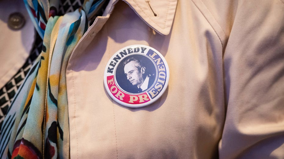 A woman wears a Kennedy for President button