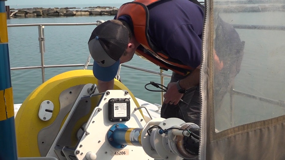 technician works on smart buoy on boat