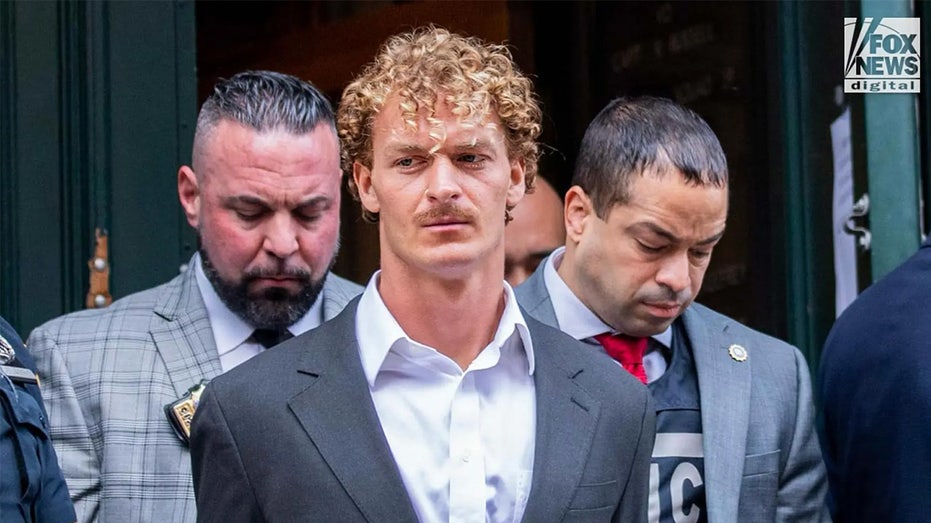 Daniel Penny in a suit escorted by two NYPD officers outside 5th Precinct in Manhattan.