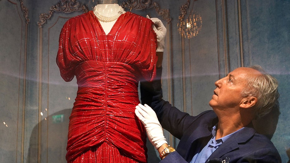 Martin Nolan touching a red dress worn by Princess Diana with white gloves