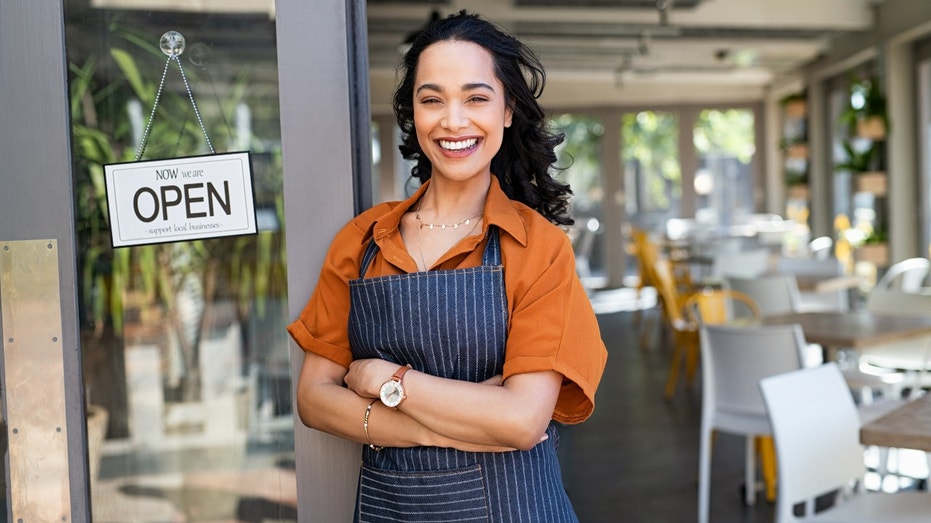 A small business owner standing outside her store