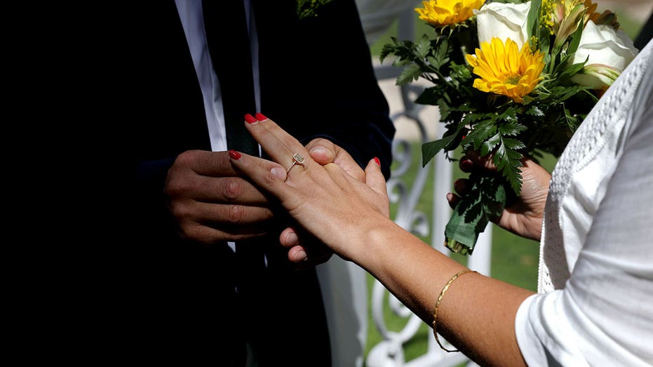 Husband puts ring on wife’s finger