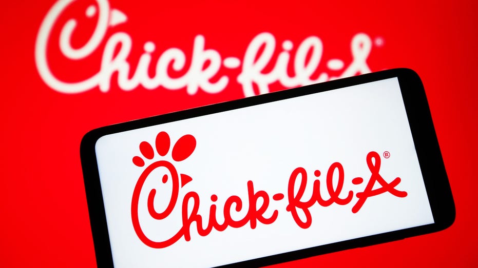 El logo de Chick-fil-A en un teléfono móvil con fondo rojo