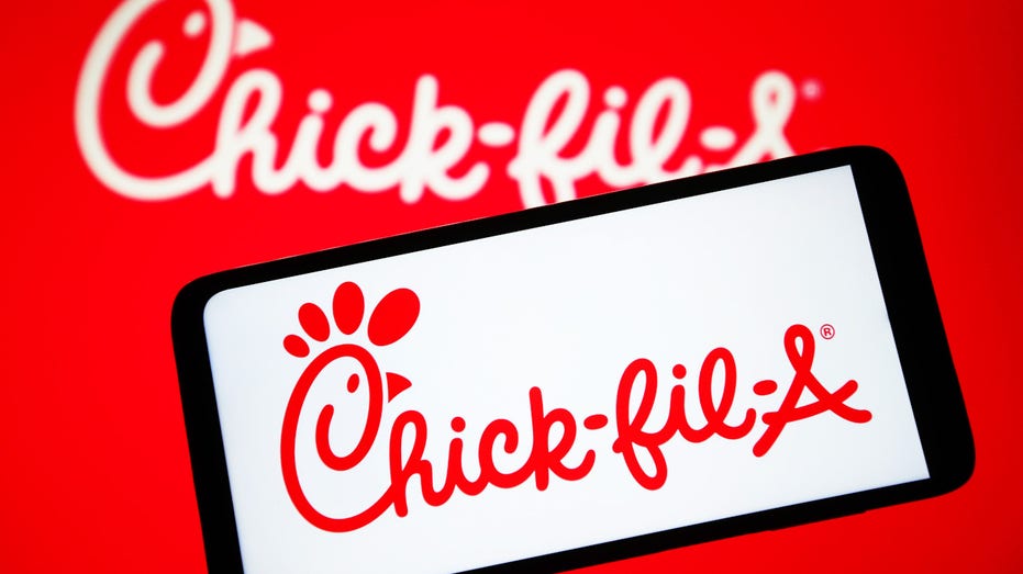 El logo de Chick-fil-A en un teléfono móvil con fondo rojo