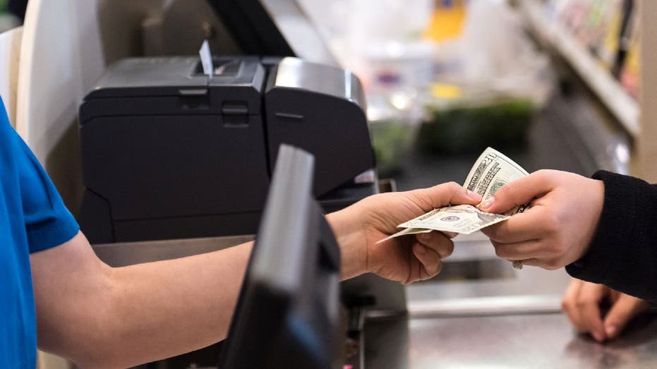 Person hands over cash to cashier