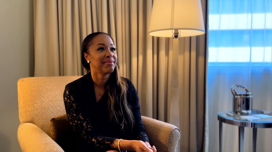 Nicole Valnetine of the Milken Institute interviews sits in a hotel room for an interview.