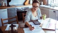Close up of a young woman doing her bills in the kitchen - Fox News