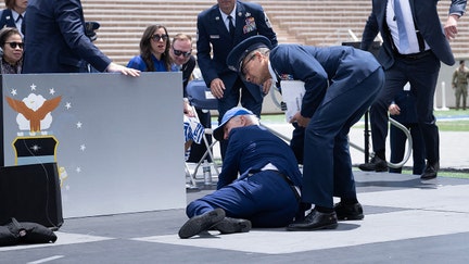 U.S. President Joe Biden is helped up after falling during the graduation ceremony at the United States Air Force Academy, just north of Colorado Springs in El Paso County, Colorado, on June 1, 2023. 