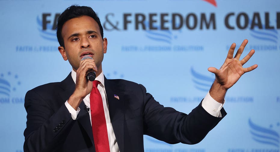 Vivek Ramaswamy wears suit and tie as he speaks into microphone at Iowa event