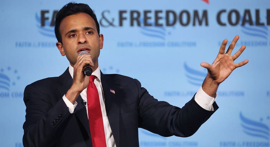 Vivek Ramaswamy wears suit and tie as he speaks into microphone at Iowa event