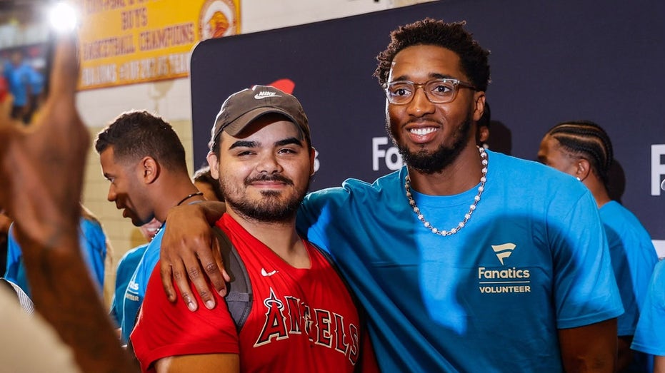 Donovan Mitchell poses with kid