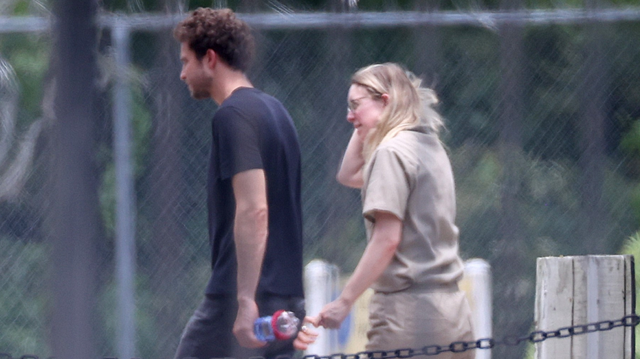 Elizabeth Holmes walks with husband at prison