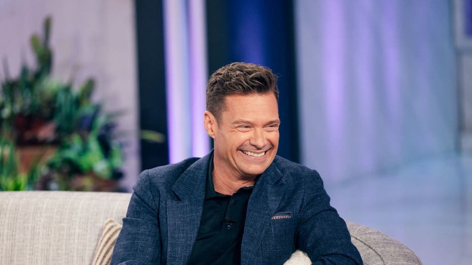 ryan seacrest smiling on couch