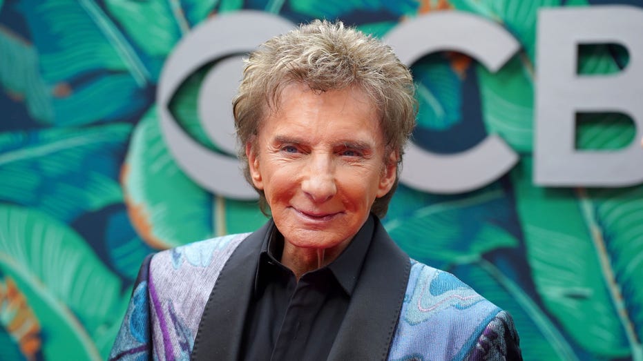 Barry Manilow wears a shiny purple suit on the red carpet