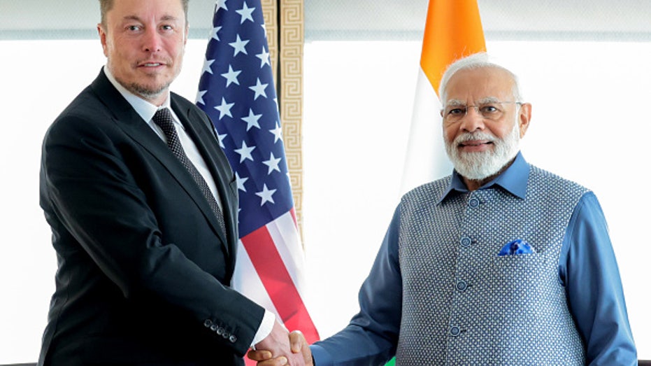 Tesla CEO Elon Musk and Indian Prime Minister Narendra Modi shake hands