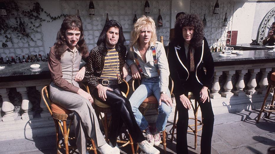 queen band members sitting on stools in group shot
