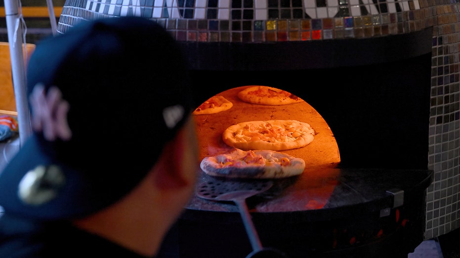 Pizza going in wood-fired oven