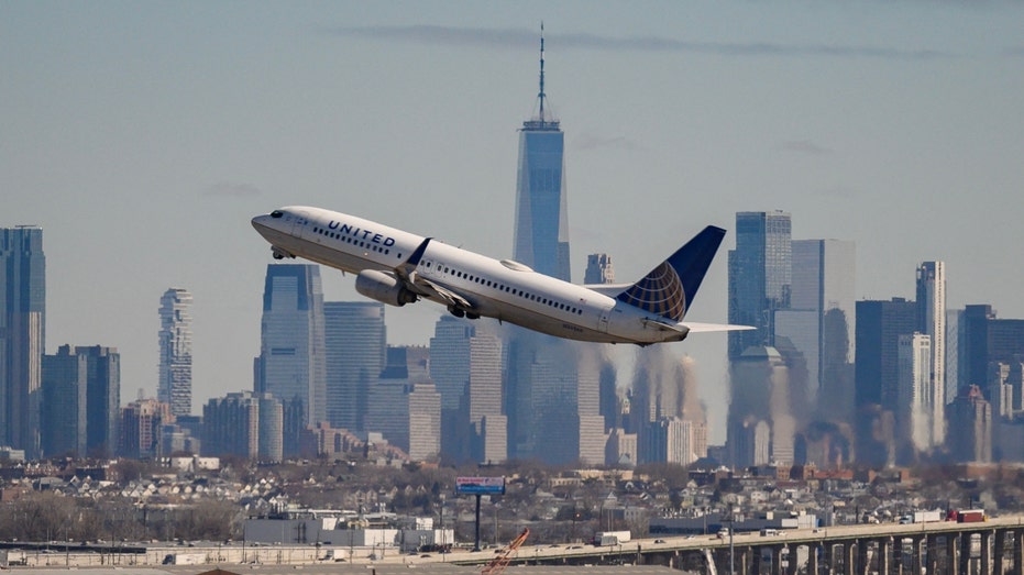 A United Airlines aircraft takes off in front of New York City's skyline