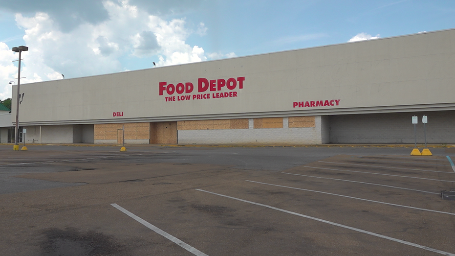 Large grocery store with doors and windows boarded up