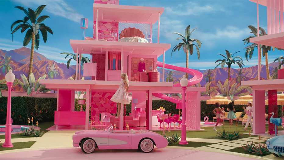 Pink Barbie Dreamhouse from the film "Barbie" with Margot Robbie floating down from an upper level to her pink car