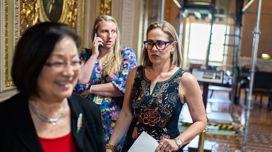 Sen. Kyrsten Sinema walks in Capitol hallway