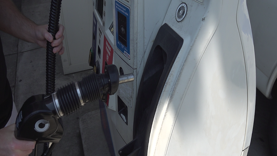 Person holding gas handle at pump