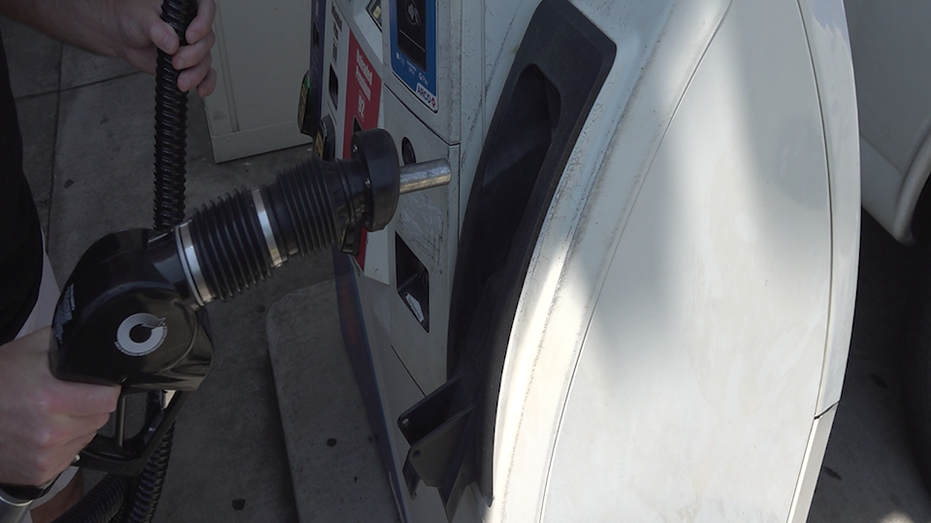 Person holding gas handle at pump