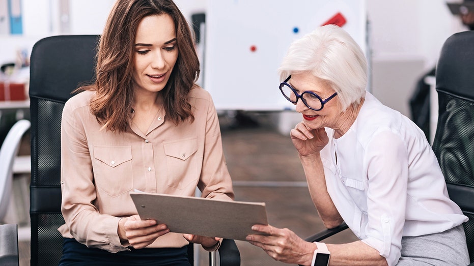 a young and old employee work together