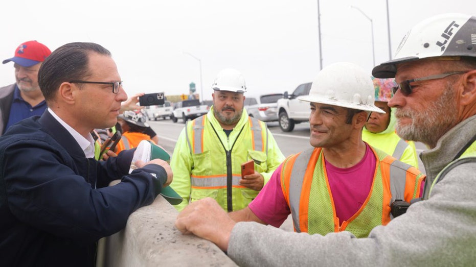 Pennsylvania Gov. Josh Shapiro speaks with construction workers on I-95