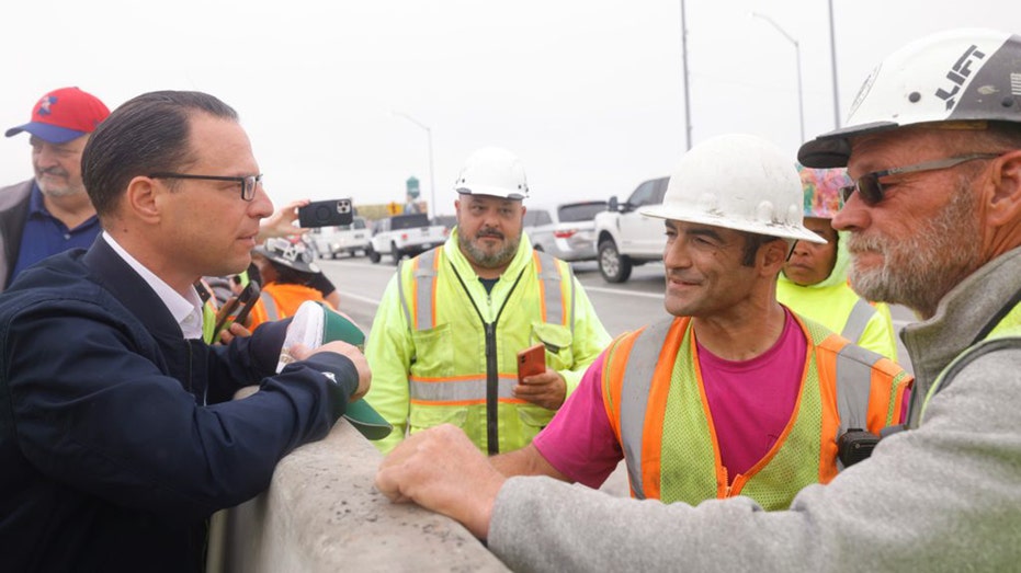 Pennsylvania Gov. Josh Shapiro speaks with construction workers on I-95