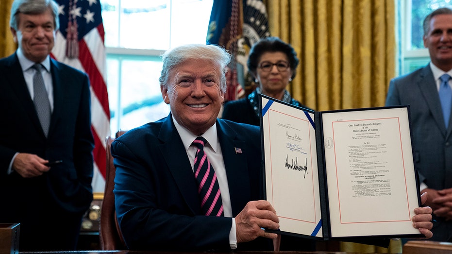 President Donald Trump signs the PPP program into law
