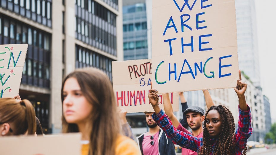 protesters marching, holding signs