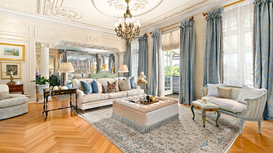 Rod Stewart's massive bedroom has blue curtains, a couch and ottoman