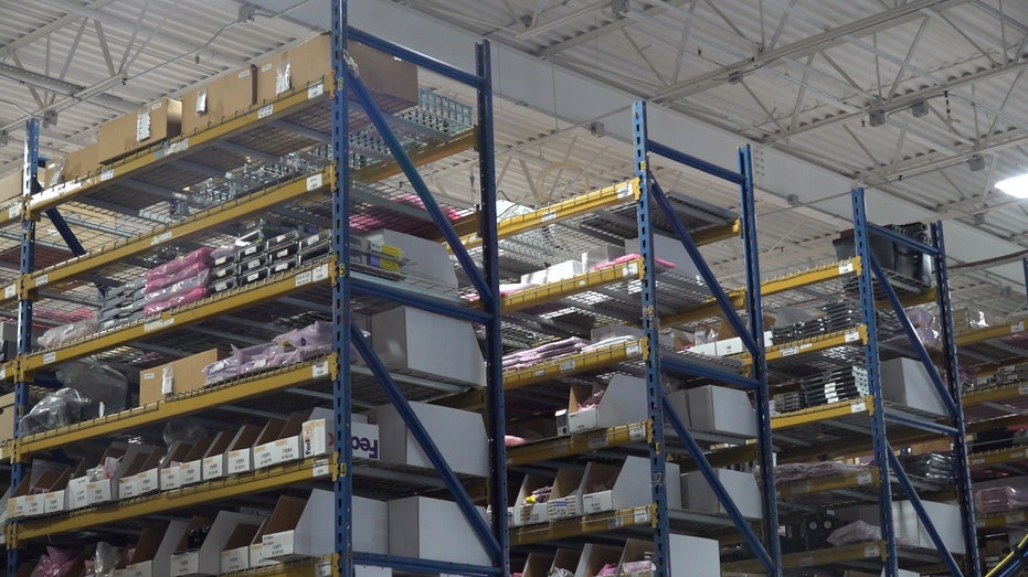 shelves of pallet racks hold IT equipment parts