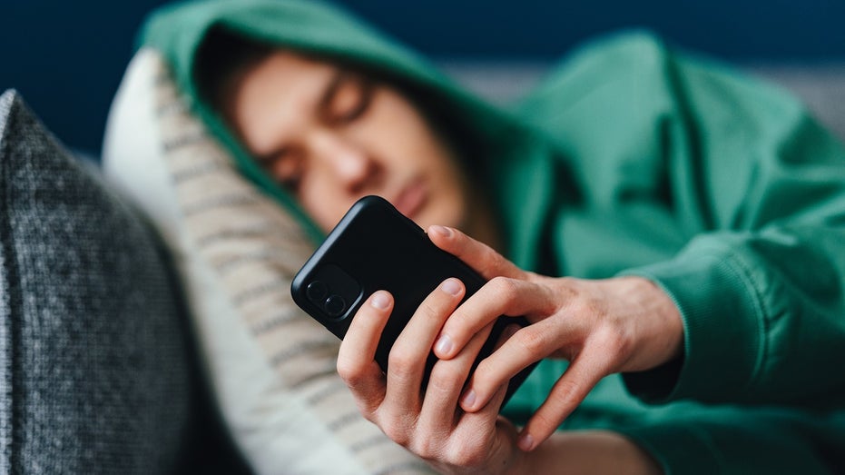 teen on couch on iPhone