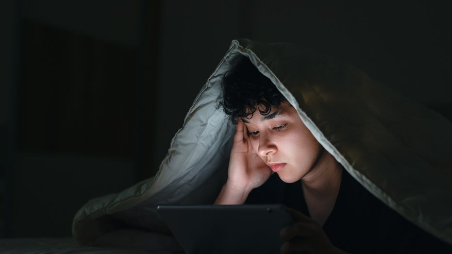 teen in bed on social media at night