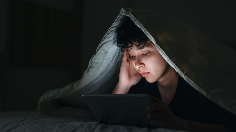 teen in bed on social media at night