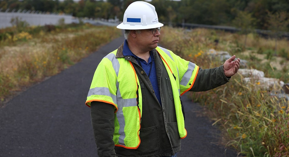 Construction contractor directs workers on road