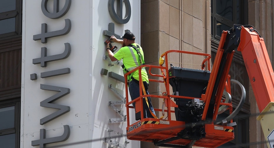 A worker removes letters from the Twitter sign