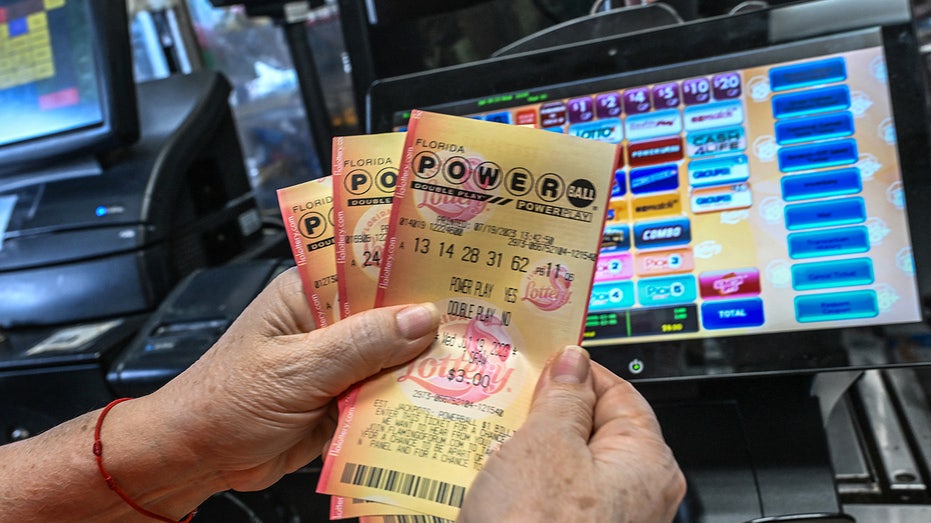 A woman holds Powerball lottery tickets inside a store in Homestead, Florida on July 19, 2023.  (GIORGIO VIERA/AFP via Getty Images / Getty Images)