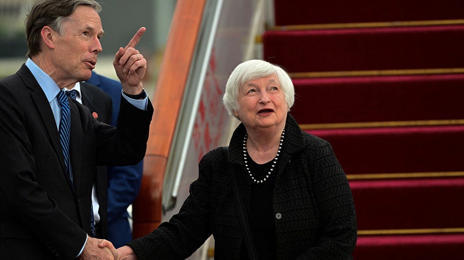 Yellen shakes hands after landing in Beijing