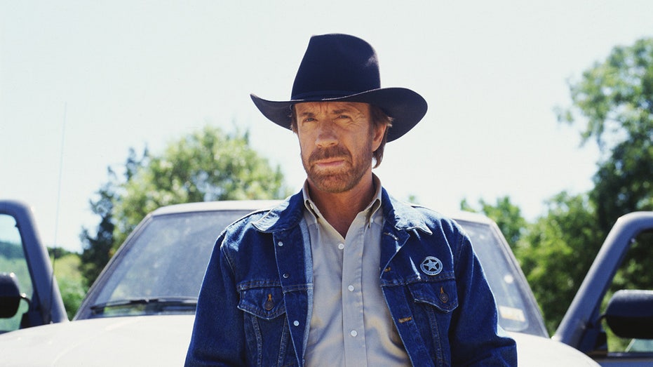 Chuck Norris as Walker leaning against a pickup