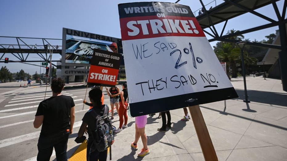 Strikers hold signs at Universal Studios